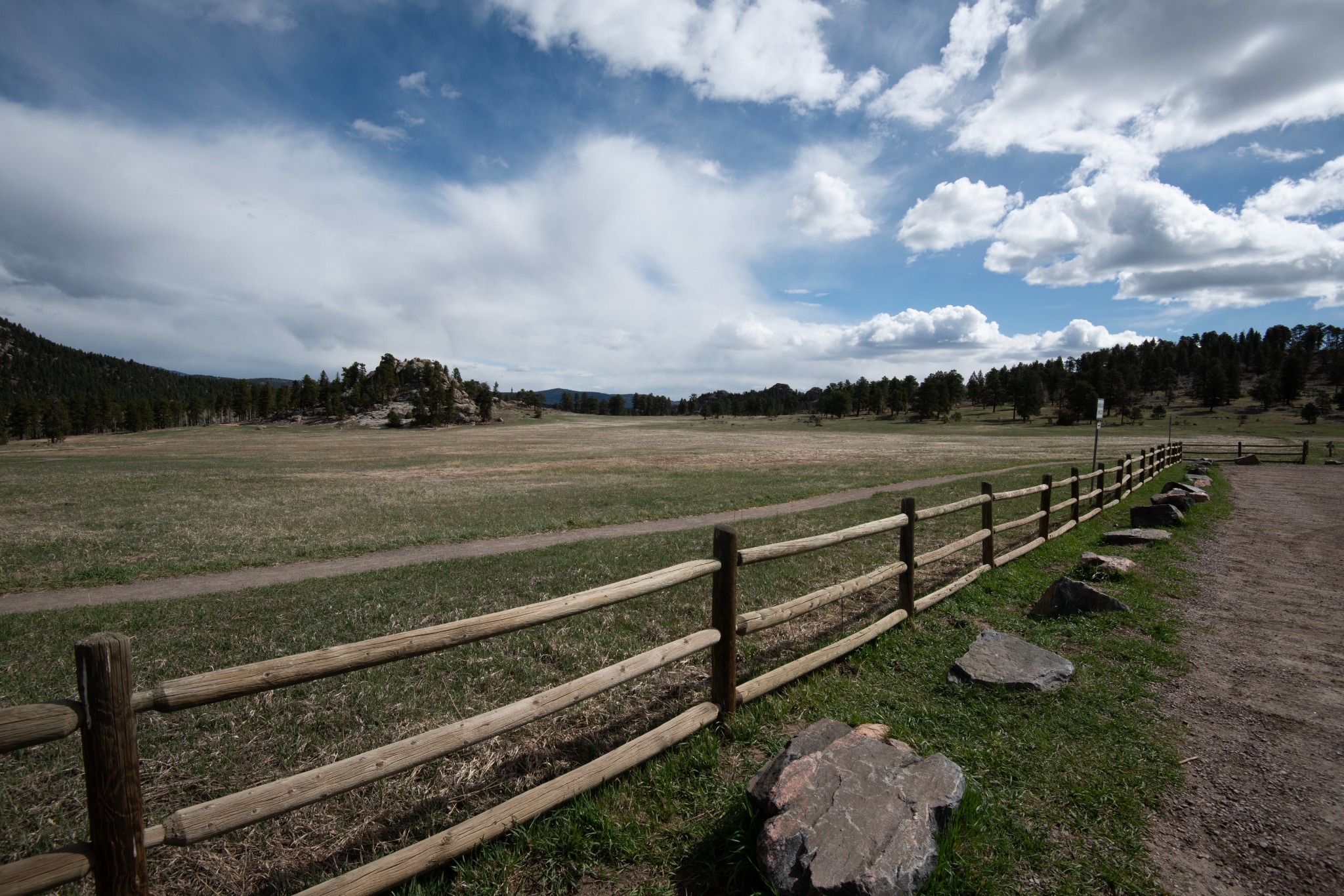 Jefferson County landscape with meadow, split-rail fence, rocky hills and dramatic sky